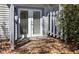 A back door with enclosed blinds, exterior lighting, and a small concrete patio covered in leaves at 2362 Parsonage Rd # 17G, Charleston, SC 29414