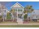 Charming two-story home features a double porch, palm trees, and a well-manicured lawn, with a classic American flag at 2506 Gatewood St, Charleston, SC 29492