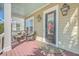 Inviting front porch features comfortable seating, a stylish rug, and a classic glass-paneled door with side lights at 2506 Gatewood St, Charleston, SC 29492
