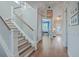 Inviting hallway with hardwood floors, staircase with white railing, and a view into the blue home office at 2506 Gatewood St, Charleston, SC 29492