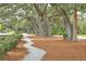 Picturesque landscaping featuring stately trees, winding pathways, and manicured shrubbery enhances the property's curb appeal at 2506 Gatewood St, Charleston, SC 29492