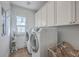 Well-lit laundry room with front load washer and dryer, white cabinets, and a practical drying rack at 2506 Gatewood St, Charleston, SC 29492