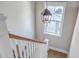 Staircase with a wood handrail illuminated by a stylish lantern pendant at 2506 Gatewood St, Charleston, SC 29492
