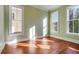Bright bedroom with hardwood floors, three large windows, and light green walls at 26 Saturday Rd, Mount Pleasant, SC 29464