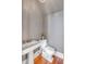Small gray powder room with pedestal sink, toilet, and wood floors at 26 Saturday Rd, Mount Pleasant, SC 29464