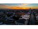 Sunset aerial view of the building and the surrounding neighborhood, highlighting a rooftop deck and city skyline at 29 Broad St # A C, Charleston, SC 29401