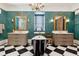 Stunning bathroom featuring a black and white tiled floor, freestanding tub, and double vanity sinks with gold accents at 29 Broad St # A C, Charleston, SC 29401