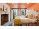 Cozy bedroom featuring a fireplace, patterned bedspread, and sunlit windows with views of palm trees at 29 Broad St # A C, Charleston, SC 29401