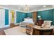 Luxurious bedroom with blue walls, a chandelier, brick accents, and comfortable seating area at 29 Broad St # A C, Charleston, SC 29401