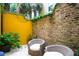 Private courtyard featuring yellow stucco and exposed brick walls with stylish outdoor furniture, perfect for relaxing and entertaining at 29 Broad St # A C, Charleston, SC 29401