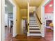 Inviting hallway with hardwood floors, staircase, and doorways leading to rooms with unique color palettes at 29 Broad St # A C, Charleston, SC 29401