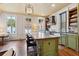 Spacious kitchen featuring an expansive center island, farmhouse sink, and hardwood floors at 29 Broad St # A C, Charleston, SC 29401