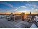 Expansive rooftop deck featuring lounge seating, a hot tub, and stunning city views at sunset at 29 Broad St # A C, Charleston, SC 29401