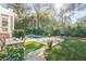 Beautiful backyard features a pool, lush landscaping, an outdoor dining area, and lounge chairs for relaxation at 309 N Civitas St, Mount Pleasant, SC 29464