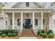 Inviting front entrance with classic black door, brick steps, white railings and manicured landscaping at 309 N Civitas St, Mount Pleasant, SC 29464
