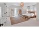 Bright bedroom featuring woven bedframe, jute rug, and beaded chandelier at 309 N Civitas St, Mount Pleasant, SC 29464