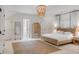 Light-filled bedroom with a woven bedframe, jute rug, and stylish chandelier at 309 N Civitas St, Mount Pleasant, SC 29464