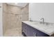 Bathroom with tiled shower, glass door, and double sink vanity with marble countertop at 339 Cabell St, Charleston, SC 29407