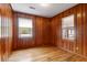 Wood paneled bedroom with hardwood flooring and two windows with view of the outdoors at 339 Cabell St, Charleston, SC 29407