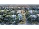 Aerial view showcasing homes nestled among lush greenery with a beautiful beach visible in the background at 4000 Cameron Blvd, Isle of Palms, SC 29451