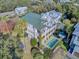 Expansive aerial view of a charming two-story home with a private pool, balconies, and lush landscaping at 4000 Cameron Blvd, Isle of Palms, SC 29451