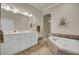 Bright bathroom features a double vanity, soaking tub with decorative tile surround, and a glass enclosed shower at 4000 Cameron Blvd, Isle of Palms, SC 29451
