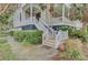 Inviting front porch with stairs, adorned with palm trees and lush landscaping at 4000 Cameron Blvd, Isle of Palms, SC 29451