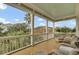 Inviting porch has comfortable wicker seating, white railings, and views of the palm trees at 4000 Cameron Blvd, Isle of Palms, SC 29451