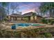 A kidney-shaped pool and spa are surrounded by a flagstone patio and mature palms at 4140 Club Course Dr, North Charleston, SC 29420