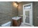 Stylish powder room with decorative wallpaper, granite counters, and a door with a decorative window at 4140 Club Course Dr, North Charleston, SC 29420