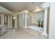 A bright bathroom featuring a large tub with pillars, glass block, and tiled floor at 4140 Club Course Dr, North Charleston, SC 29420