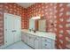Bright bathroom with white vanity and red patterned wallpaper at 4140 Club Course Dr, North Charleston, SC 29420