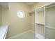 A closet with white shelving and rods with window on beige carpet at 4140 Club Course Dr, North Charleston, SC 29420