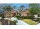 Inviting brick home showcasing a circular driveway, lush landscaping, and manicured lawn at 4140 Club Course Dr, North Charleston, SC 29420