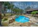 Backyard pool oasis with stone patio, spa, and lush landscaping perfect for relaxation and entertaining at 4140 Club Course Dr, North Charleston, SC 29420