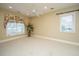 A bright, carpeted room with two windows, one with floral curtains, and a ceiling fan at 4140 Club Course Dr, North Charleston, SC 29420