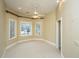 A bright, carpeted room with three windows and a ceiling fan at 4140 Club Course Dr, North Charleston, SC 29420