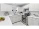 Bright kitchen with stainless steel appliances, white cabinets, and tile backsplash with a view to the outside at 4850 Habersham Ln, Summerville, SC 29485
