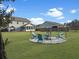 Spacious backyard with lush green grass, a cozy fire pit area, and mature landscaping at 502 Pontoon Rd, Huger, SC 29450