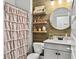 Charming bathroom featuring wood accent wall, floating shelves, and round mirror over a modern vanity at 502 Pontoon Rd, Huger, SC 29450