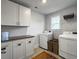 Well-equipped laundry room with modern appliances, ample cabinet space, and a convenient folding area at 502 Pontoon Rd, Huger, SC 29450