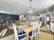 Open-concept living space with dining area, sofa, and kitchen with white cabinets at 502 Pontoon Rd, Huger, SC 29450