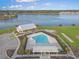 Aerial view of a community pool, lake, clubhouse, and lush landscaping with palm trees at 502 Pontoon Rd, Huger, SC 29450