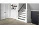 Staircase with carpeted treads and white risers, complemented by a white wall and dark wood railing at 502 Pontoon Rd, Huger, SC 29450