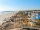 Aerial view of beachfront homes with walkways to a wide sandy beach and stunning ocean views at 511 W Ashley Ave, Folly Beach, SC 29439