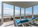 Covered porch with blue cushioned outdoor furniture, beautiful ocean views, and sunny skies at 511 W Ashley Ave, Folly Beach, SC 29439