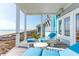 Covered porch with blue cushioned outdoor furniture with ocean views at 511 W Ashley Ave, Folly Beach, SC 29439