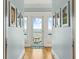 Hallway with ocean view at the end, wood floors, and decor on the walls at 511 W Ashley Ave, Folly Beach, SC 29439