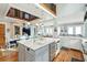 Open concept kitchen and dining area with balcony view, a marble island, stainless steel appliances, and wooden floors at 511 W Ashley Ave, Folly Beach, SC 29439
