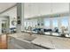 Eat-in kitchen island with white cabinets and marble countertop leading to the living room with ocean view at 511 W Ashley Ave, Folly Beach, SC 29439